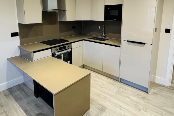 Cream high-gloss handleless U-shaped kitchen in Ilford with peninsula breakfast bar