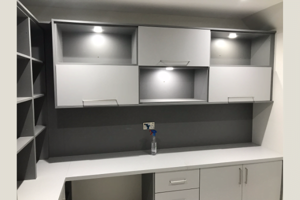 Dove-grey and white matt fitted home office in London with wall-mounted cabinets and LED downlights