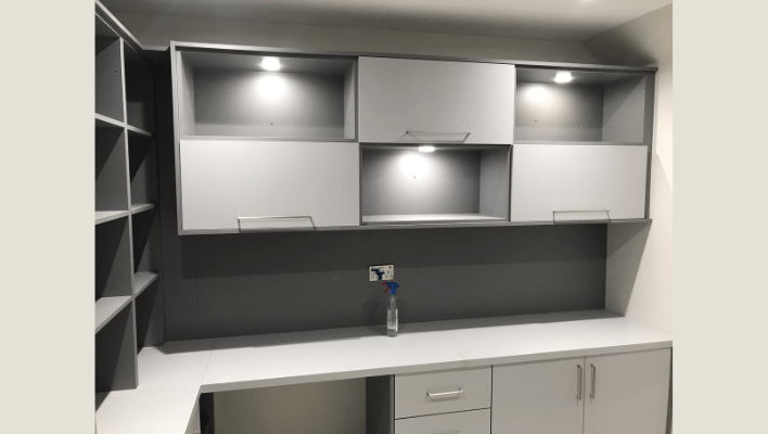 Dove-grey and white matt fitted home office in London with wall-mounted cabinets and LED downlights