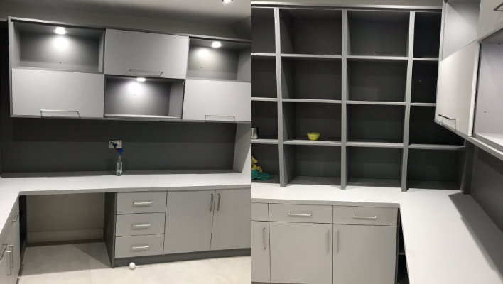 Second view of dove-grey and white home office in London showing open shelving and desk cabinets
