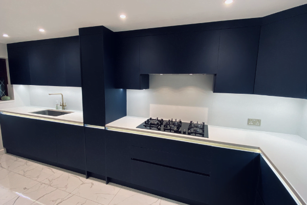 Fifth view of navy matt handleless kitchen in Edgware with gold finger-pull trim and white quartz worktop