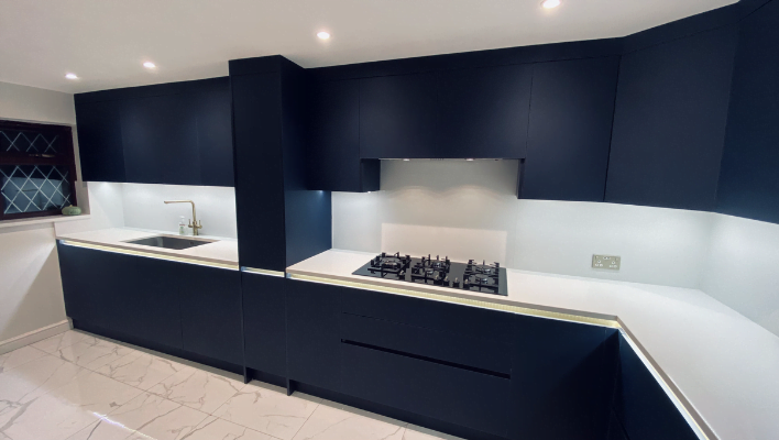 Fifth view of navy matt handleless kitchen in Edgware with gold finger-pull trim and white quartz worktop