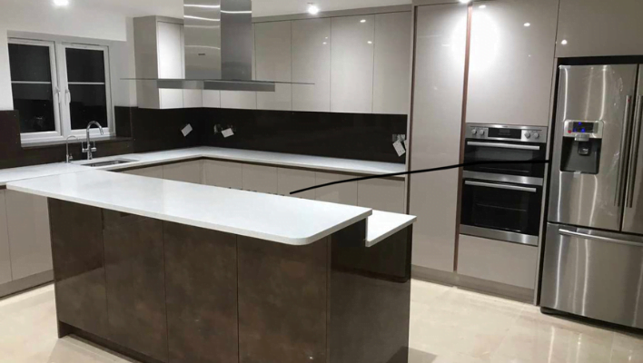 Integrated American fridge freezer and built-in double oven tower in light grey gloss London kitchen