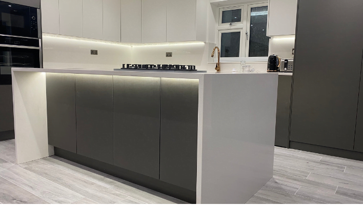Fourth view of matt khaki-green handleless kitchen in Isleworth with waterfall quartz island