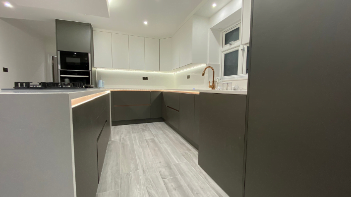 Sixth view of matt khaki-green handleless kitchen in Isleworth with waterfall quartz island