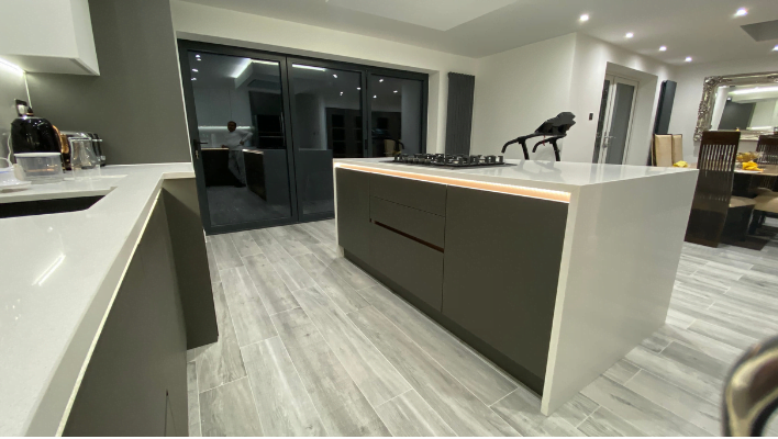 Eighth view of matt khaki-green handleless kitchen in Isleworth with waterfall quartz island