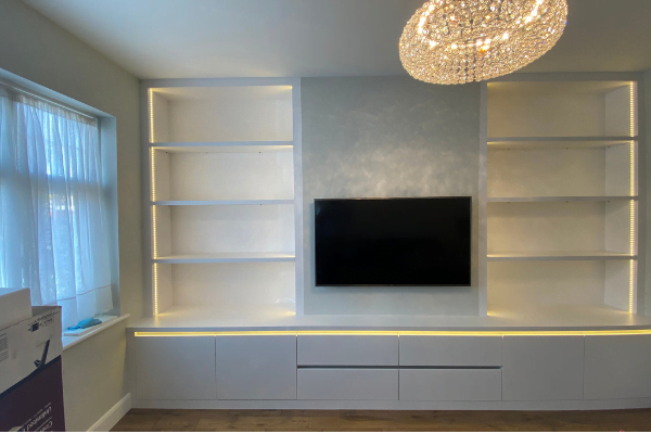 Second view of oak slat media wall with dark wood floating unit and open shelving tower
