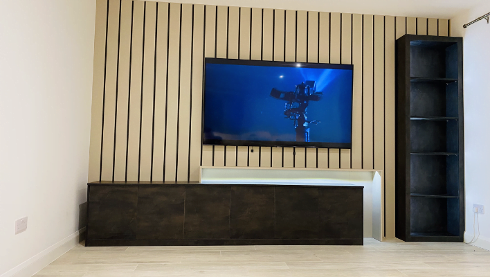 Oak slatted media wall with floating dark wood TV unit and tall open shelving storage tower