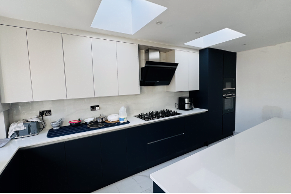 White quartz island with integrated gas hob and angled extractor in Romford kitchen extension