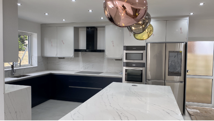 Two-tone navy and white gloss kitchen in Putney with Calacatta marble-effect waterfall island