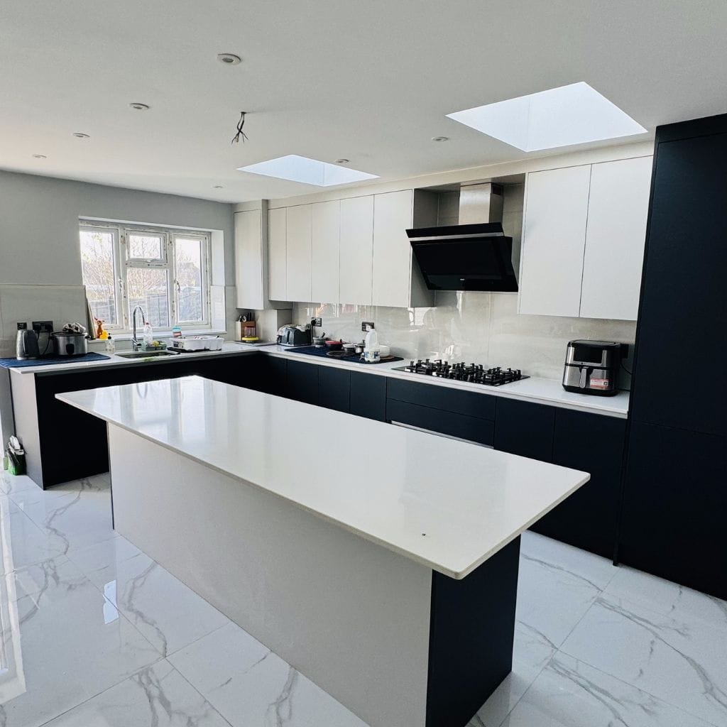 Handleless kitchen in navy matt and white gloss with quartz island and twin skylights