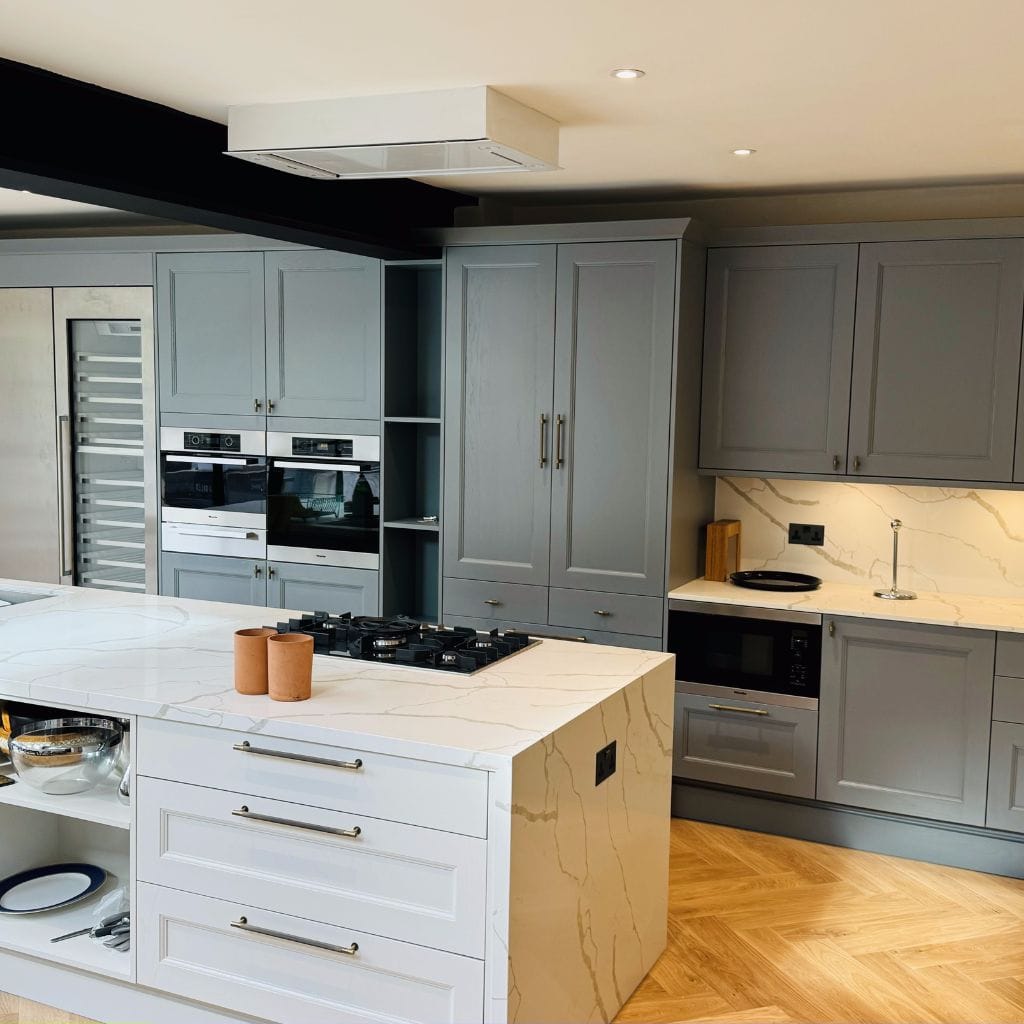 In-frame shaker kitchen in painted grey with Calacatta quartz island, integrated appliances and herringbone parquet floor