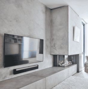 Modern concrete-look media wall with recessed fireplace and mounted TV in a stylish British flat